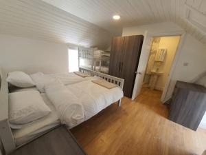 1 dormitorio con 1 cama grande con sábanas blancas en Peacock Farms Estate, en Cork