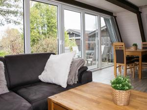 a living room with a couch and a table at Holiday Home Fedderwardersiel-6 by Interhome in Fedderwarderdeich
