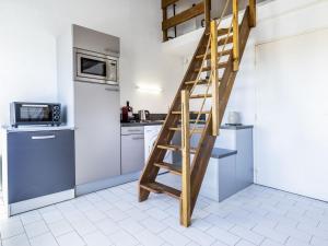 a kitchen with a wooden ladder in a kitchen at Apartment Les Frégates-15 by Interhome in Saint-Cyprien