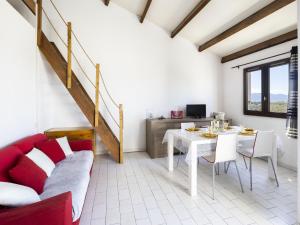 a living room with a table and a red couch at Apartment Les Frégates-15 by Interhome in Saint-Cyprien