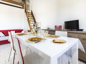 a white table with plates of food on it at Apartment Les Frégates-15 by Interhome in Saint-Cyprien