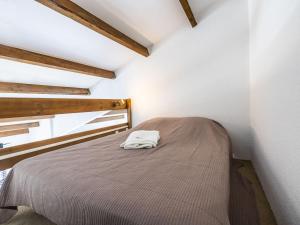 a bed in a small room with a bedspread at Apartment Les Frégates-15 by Interhome in Saint-Cyprien