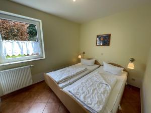 een slaapkamer met een bed en een raam bij Apartment Müritz Ferienpark Röbel-14 by Interhome in Röbel