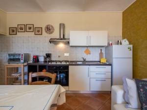 een keuken met een witte koelkast en een tafel bij Holiday Home Agriturismo I Tre Tigli by Interhome in Serravalle dʼAsti