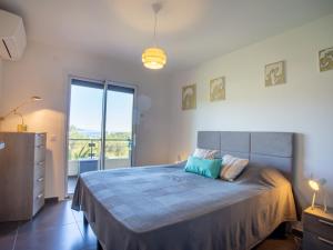 a bedroom with a large bed with a large window at Apartment Un autre jour ensoleillé by Interhome in Bormes-les-Mimosas