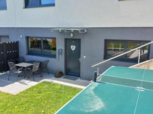 patio con mesa de ping pong y pista de tenis en Apartment Ferienwohnung Sabine by Interhome, en Oberperfuss