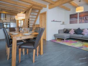 a dining room with a table and chairs and a couch at Chalet Ambigu by Interhome in Ovronnaz