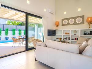 a living room with a white couch and a sliding glass door at Villa Can Aruna by Interhome in Colonia de Sant Pere