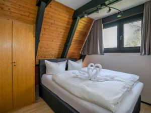 a bedroom with a bed with white blankets and pillows at Holiday Home Fedderwardersiel-5 by Interhome in Fedderwarderdeich