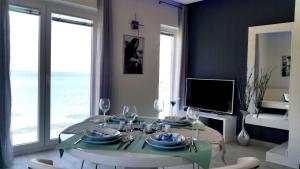 a living room with a table with chairs and a television at Apartments Sea Reflections in Žman