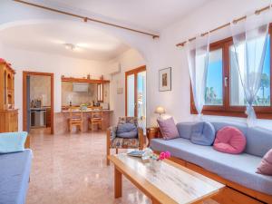 a living room with a blue couch and a table at Apartment - SNY160 by Interhome in Cala Santanyi
