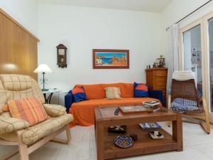 a living room with an orange couch and a table at Apartment Pomeres by Interhome in Tossa de Mar