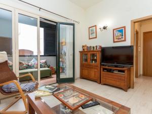 a living room with a tv and a table at Apartment Pomeres by Interhome in Tossa de Mar
