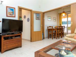 uma sala de estar com uma televisão de ecrã plano e uma mesa em Apartment Pomeres by Interhome em Tossa de Mar