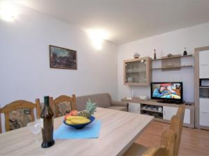 uma sala de estar com uma mesa com uma taça de fruta e uma televisão em Holiday Home Aurora by Interhome em Skradin