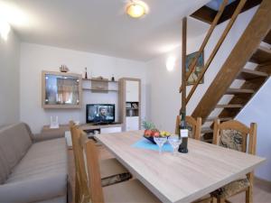 uma sala de jantar e sala de estar com uma mesa e um sofá em Holiday Home Aurora by Interhome em Skradin