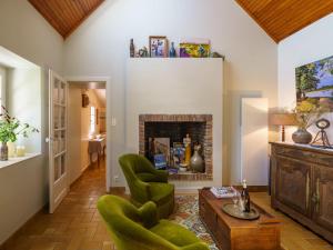 - un salon avec des chaises vertes et une cheminée dans l'établissement Holiday Home Entre terre et mer by Interhome, à Pouldreuzic