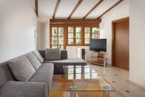 a living room with a couch and a tv at Villa Fuzzys - Un antico casale ristrutturato in Malcesine