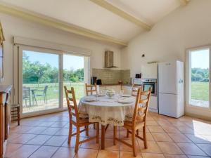 eine Küche und ein Esszimmer mit einem Tisch und Stühlen in der Unterkunft Holiday Home Capucine de Tracanet by Interhome in Gaillan-en-Médoc