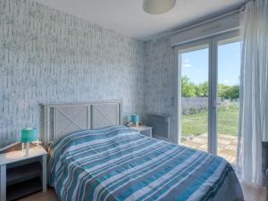 ein Schlafzimmer mit einem Bett und einem großen Fenster in der Unterkunft Holiday Home Capucine de Tracanet by Interhome in Gaillan-en-Médoc