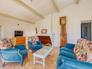 ein Wohnzimmer mit blauen Stühlen und einer Uhr in der Unterkunft Holiday Home Capucine de Tracanet by Interhome in Gaillan-en-Médoc