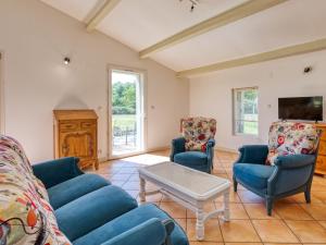 ein Wohnzimmer mit blauen Sofas und einem Couchtisch in der Unterkunft Holiday Home Capucine de Tracanet by Interhome in Gaillan-en-Médoc