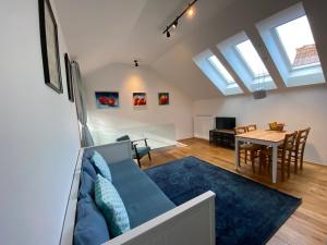 a living room with a blue couch and a table at Krakovska apartments in Ljubljana