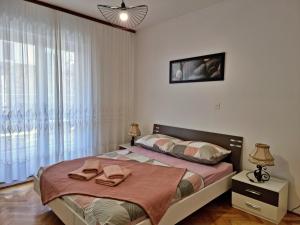 Un dormitorio con una cama y una ventana grande. en Apartment Hana, en Omiš