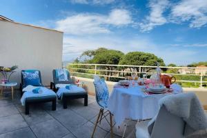 eine Terrasse mit einem Tisch und Stühlen auf dem Balkon in der Unterkunft Appartement Pearl Beach in Saint-Tropez