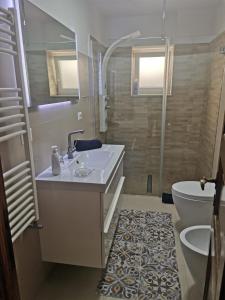 y baño con lavabo, aseo y ducha. en Villa Sea view con terrazza e giardino, en Capri