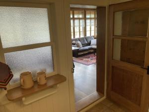 a door leading to a living room with a couch at Apartment Chalet Stöckli by Interhome in Kandersteg