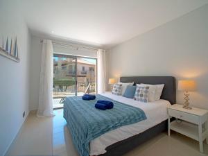ein Schlafzimmer mit einem großen Bett und einem großen Fenster in der Unterkunft Apartment Pine Hills Ambar by Interhome in Vilamoura
