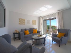 ein Wohnzimmer mit blauen Sofas und einem Tisch in der Unterkunft Apartment Pine Hills Ambar by Interhome in Vilamoura