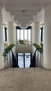 a hallway in a building with tables and chairs at Amba Hotel in Rimini