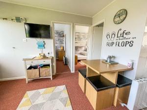 a living room with a desk and a tv at Beautiful Chalet With Free Wifi Nearby Hemsby Beach In Norfolk Ref 59096s in Hemsby