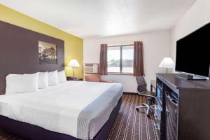 a hotel room with a large bed and a flat screen tv at Super 8 by Wyndham La Crosse in La Crosse