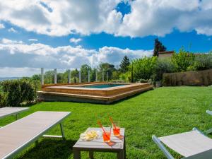 a yard with two picnic tables and a swimming pool at Apartment Cinzia by Interhome in Santa Maria a Monte