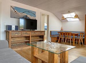 ein Wohnzimmer mit Fernseher und Tisch mit Stühlen in der Unterkunft Alpschatz Adlerhorst in Oberstdorf
