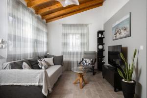 a living room with a couch and a tv at CASA DI'ELEN in Faliraki