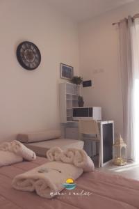 1 dormitorio con 2 camas y reloj en la pared en Mare & Relax en Margherita di Savoia