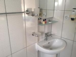 een witte badkamer met een wastafel en een spiegel bij Er-Öz Hotel in Fethiye