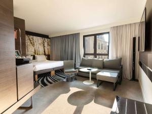 pokój hotelowy z łóżkiem i kanapą w obiekcie Novotel Suites Colmar Centre w mieście Colmar