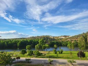 a view of a river with trees and a road at NORTHEAST PORTUGAL G in Mirandela