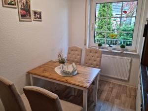 een eetkamer met een tafel en stoelen en een raam bij Hausnordlicht FEWO 1 in Dornum +19 foto's
