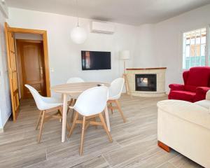 sala de estar con mesa, sillas y sofá rojo en CA LA LOLA, en Banyeres del Penedés