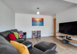 a living room with a couch and a flat screen tv at 5 The Fairway in Braunton
