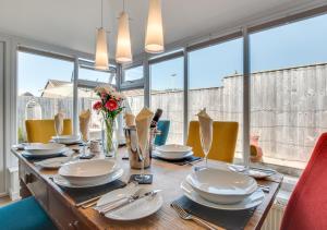 a dining room table with chairs and a large window at 5 The Fairway in Braunton