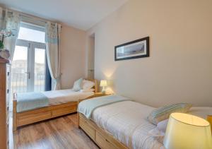 a bedroom with two beds and a window at 7 Cove View in Ilfracombe