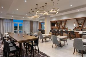 a restaurant with tables and chairs and a chandelier at Hyatt Place Fort Worth/TCU in Fort Worth