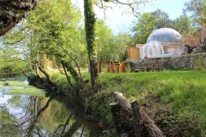 a domed observatory sitting next to a body of water at La bulle étoile in Allegre Les Fumades